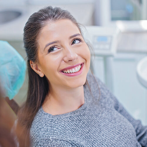 A woman smiling on the dentist chair