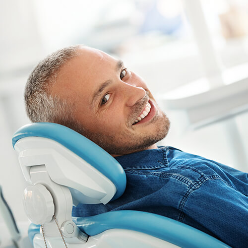 Middle age man smiling while sitting on the dentist chair