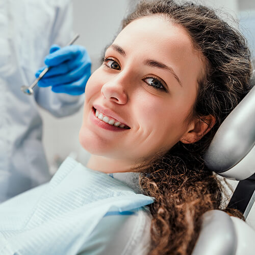 Young woman smiling at dentist chair